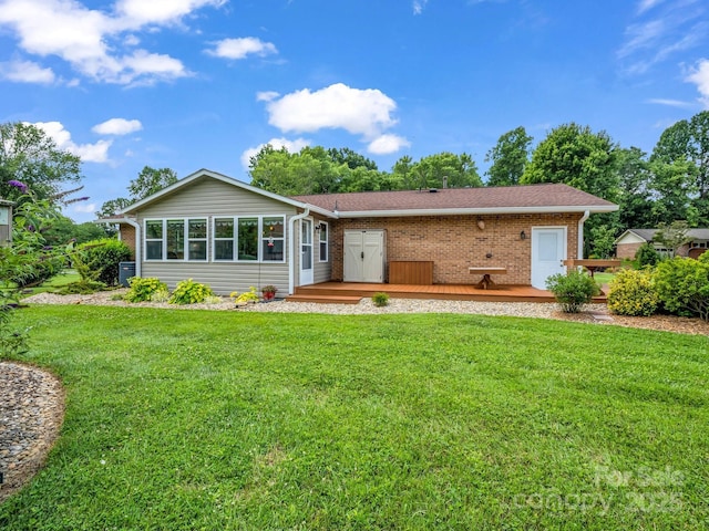 313 Resada Dr, Brevard, NC 28712 - ranch-style home with a wooden deck, brick siding, a front lawn, a sunroom, and a shingled roof