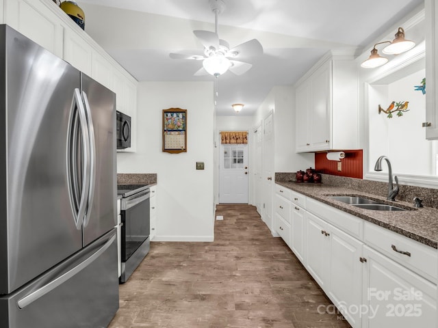 313 Resada Dr, Brevard, NC 28712 - kitchen featuring stainless steel appliances, white cabinetry, wood finished floors, and a ceiling fan