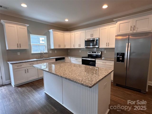 2261 Moss Haven Ln, Denver, NC 28037 - kitchen featuring appliances with stainless steel finishes, a center island, white cabinets, dark wood-style flooring, and backsplash