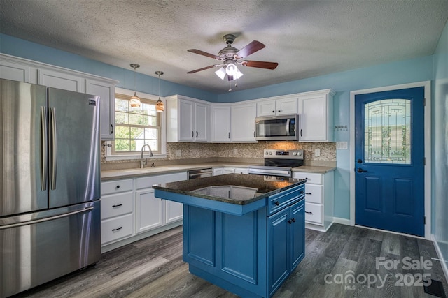 207 Valdese Dr, Morganton, NC 28655 - kitchen with stainless steel appliances, blue cabinetry, white cabinets, dark wood-type flooring, and a textured ceiling