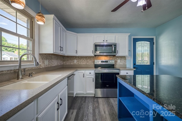 207 Valdese Dr, Morganton, NC 28655 - kitchen with stainless steel appliances, dark wood-type flooring, white cabinetry, ceiling fan, and decorative light fixtures