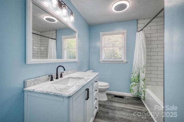 207 Valdese Dr, Morganton, NC 28655 - full bathroom featuring vanity, a textured ceiling, wood finished floors, and shower / tub combo
