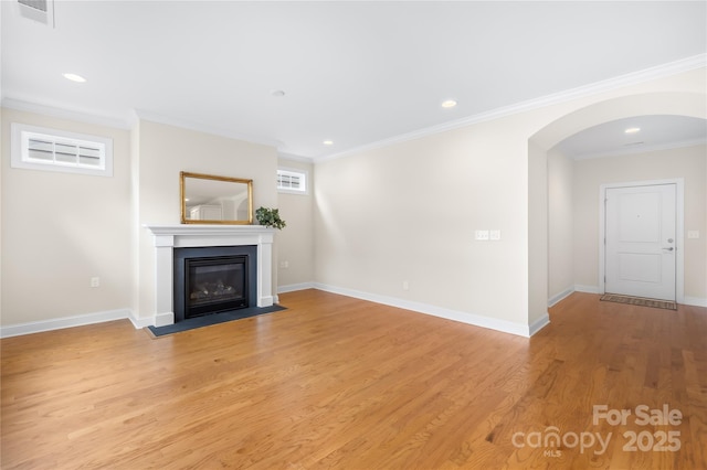 135 Valleymist Ln, Mooresville, NC 28117 - unfurnished living room with arched walkways, light wood-type flooring, a fireplace with flush hearth, crown molding, and recessed lighting