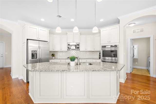 135 Valleymist Ln, Mooresville, NC 28117 - kitchen with stainless steel appliances, arched walkways, ornamental molding, white cabinets, and tasteful backsplash