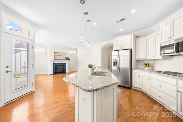 135 Valleymist Ln, Mooresville, NC 28117 - kitchen with appliances with stainless steel finishes, an island with sink, arched walkways, white cabinets, and recessed lighting