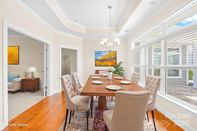 135 Valleymist Ln, Mooresville, NC 28117 - dining room with plenty of natural light, a chandelier, ornamental molding, a raised ceiling, and wood finished floors