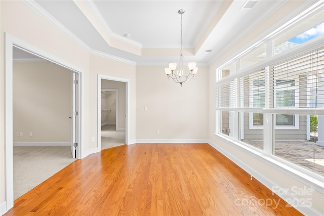 135 Valleymist Ln, Mooresville, NC 28117 - empty room with a chandelier, crown molding, a tray ceiling, and light wood-type flooring