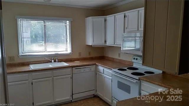 11 Lake Dr Unit B-1, Hendersonville, NC 28739 - kitchen featuring white appliances, white cabinetry, ornamental molding, and light countertops
