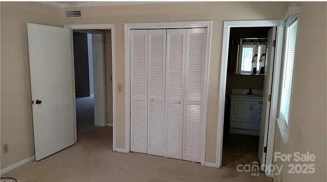 11 Lake Dr Unit B-1, Hendersonville, NC 28739 - unfurnished bedroom featuring a closet, carpet, and crown molding