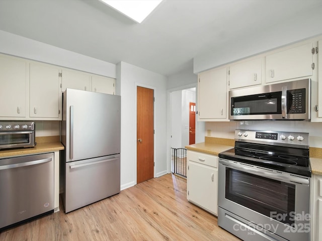312 Garrison Dr, Albemarle, NC 28001 - kitchen with stainless steel appliances, light countertops, and light wood-style flooring