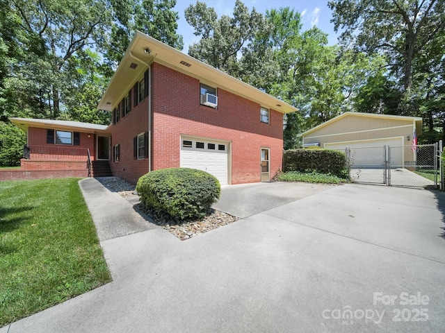 312 Garrison Dr, Albemarle, NC 28001 - view of front facade with brick siding, a gate, concrete driveway, and an attached garage
