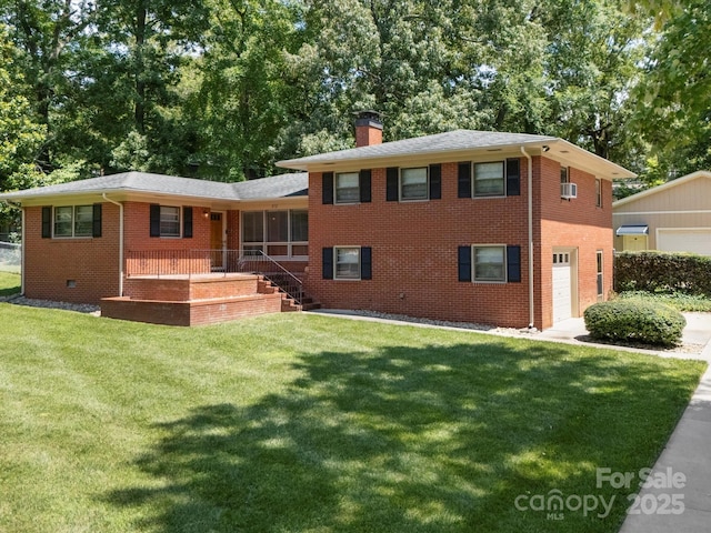 312 Garrison Dr, Albemarle, NC 28001 - tri-level home with brick siding, a front lawn, a chimney, covered porch, and an attached garage