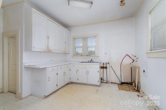 4712 Mooresville Rd, Salisbury, NC 28147 - kitchen featuring light floors, light countertops, white cabinetry, and crown molding