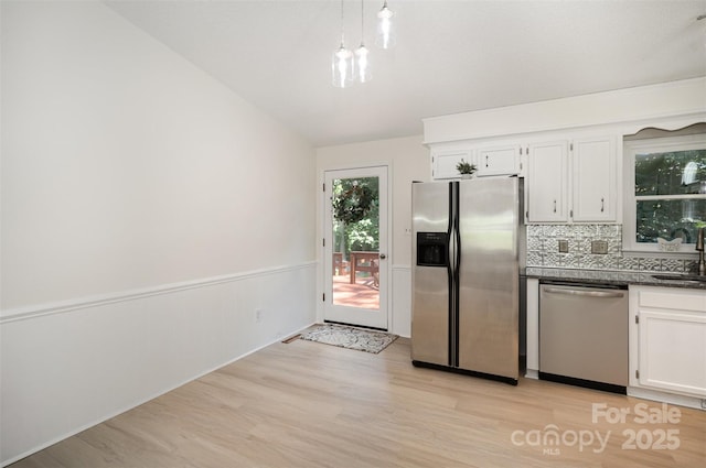 256 Timberland Loop, Mooresville, NC 28115 - kitchen featuring appliances with stainless steel finishes, light wood-style flooring, white cabinetry, a wainscoted wall, and lofted ceiling