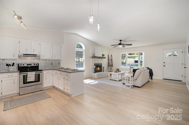 256 Timberland Loop, Mooresville, NC 28115 - kitchen with stainless steel electric range oven, vaulted ceiling, under cabinet range hood, a brick fireplace, and open floor plan