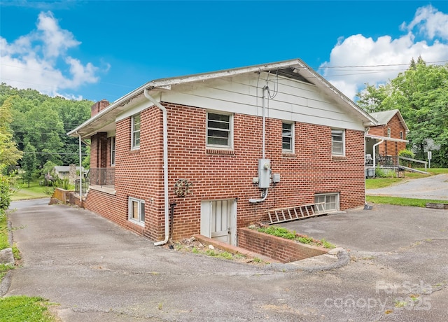 3575 Dellwood Rd, Waynesville, NC 28786 - view of home's exterior with asphalt driveway, a chimney, and brick siding