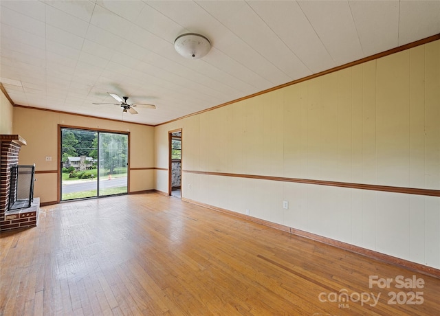 3575 Dellwood Rd, Waynesville, NC 28786 - unfurnished living room featuring ornamental molding, ceiling fan, hardwood / wood-style floors, and a brick fireplace