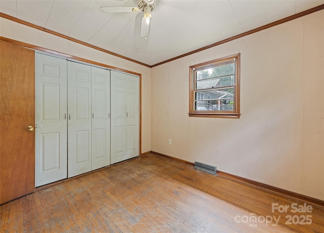 3575 Dellwood Rd, Waynesville, NC 28786 - unfurnished bedroom featuring crown molding, hardwood / wood-style flooring, a closet, and ceiling fan