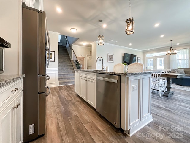1024 Laggan Ln Unit 255, Indian Trail, NC 28079 - kitchen with stainless steel appliances, open floor plan, light stone counters, ornamental molding, and dark wood-type flooring