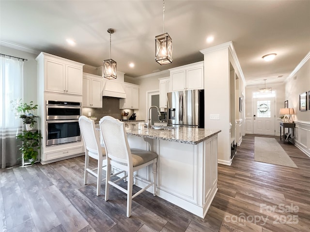 1024 Laggan Ln Unit 255, Indian Trail, NC 28079 - kitchen with stainless steel appliances, ornamental molding, light stone counters, dark wood finished floors, and a center island with sink