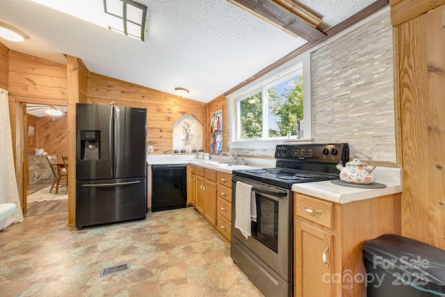 19 Timbers Edge Ln, Fairview, NC 28730 - kitchen with stainless steel appliances, a textured ceiling, wooden walls, vaulted ceiling, and light stone finish floors