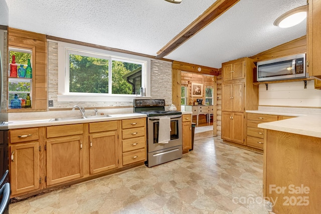 19 Timbers Edge Ln, Fairview, NC 28730 - kitchen featuring appliances with stainless steel finishes, a textured ceiling, wooden walls, light countertops, and brown cabinetry