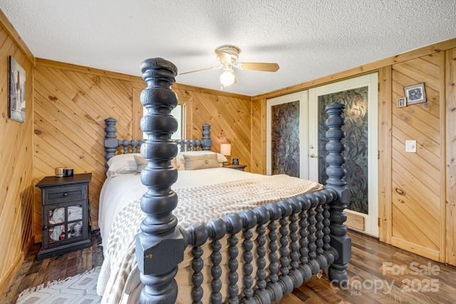 19 Timbers Edge Ln, Fairview, NC 28730 - bedroom featuring a textured ceiling, wood finished floors, wooden walls, and a ceiling fan