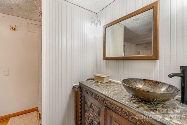 19 Timbers Edge Ln, Fairview, NC 28730 - bathroom featuring a textured ceiling, vanity, and wooden walls