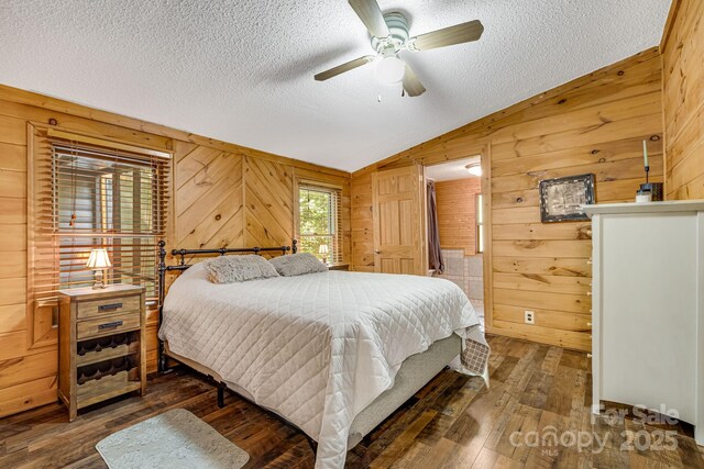 19 Timbers Edge Ln, Fairview, NC 28730 - bedroom with wooden walls, a textured ceiling, lofted ceiling, hardwood / wood-style floors, and a ceiling fan