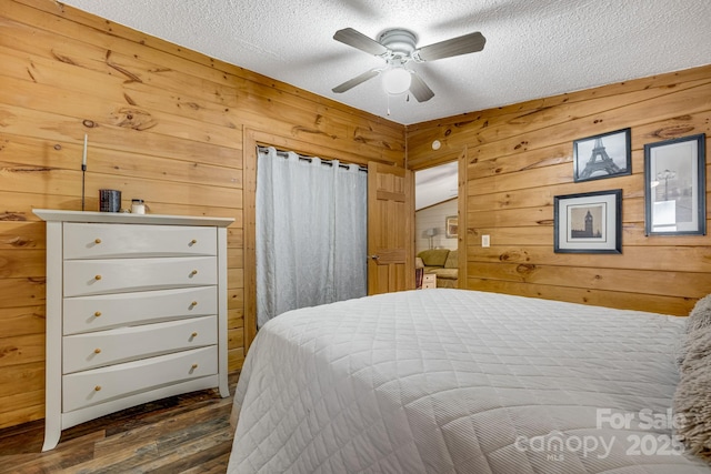 19 Timbers Edge Ln, Fairview, NC 28730 - bedroom featuring a textured ceiling, dark wood-style flooring, wooden walls, and ceiling fan