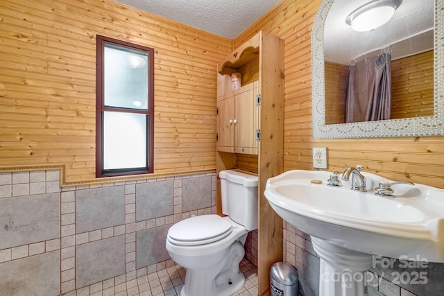 19 Timbers Edge Ln, Fairview, NC 28730 - bathroom featuring wooden walls, a textured ceiling, curtained shower, and tile patterned flooring