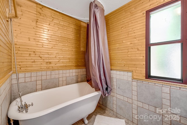 19 Timbers Edge Ln, Fairview, NC 28730 - full bathroom featuring a soaking tub, healthy amount of natural light, tile walls, and wooden walls