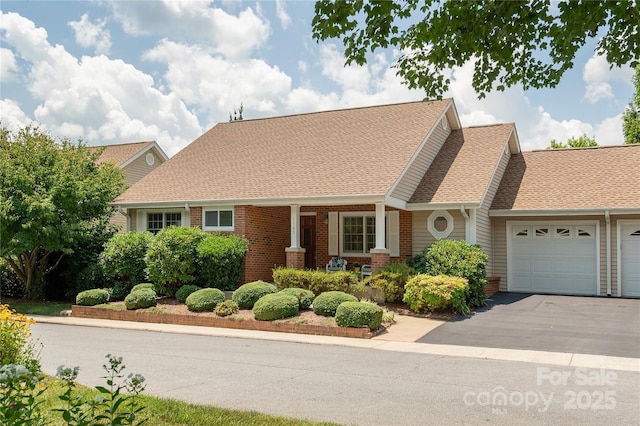 1105 Citation Cir, Hendersonville, NC 28739 - view of front of house with a garage, brick siding, driveway, and a shingled roof