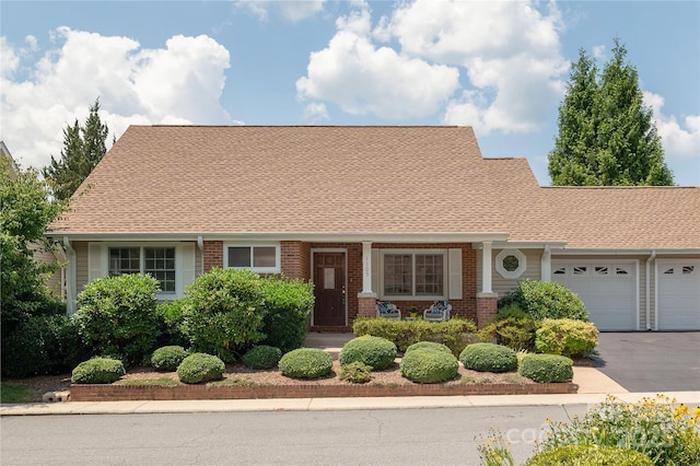 1105 Citation Cir, Hendersonville, NC 28739 - cape cod home featuring brick siding, an attached garage, roof with shingles, and driveway