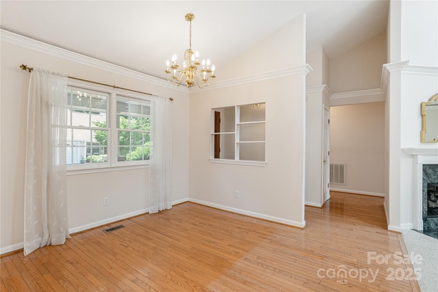 1105 Citation Cir, Hendersonville, NC 28739 - empty room featuring a chandelier, a high end fireplace, light wood finished floors, and vaulted ceiling