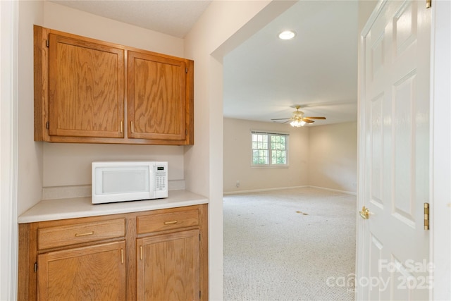 1105 Citation Cir, Hendersonville, NC 28739 - kitchen featuring white microwave, a ceiling fan, light countertops, brown cabinets, and recessed lighting