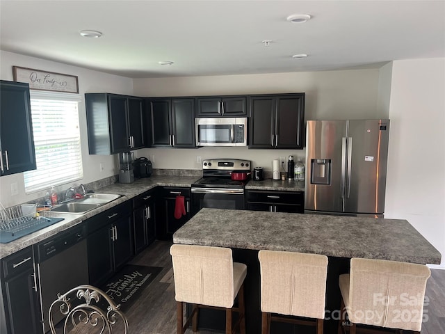 1076 Tangle Ridge Dr SE, Concord, NC 28025 - kitchen featuring stainless steel appliances, dark wood-style flooring, a breakfast bar, a kitchen island, and dark cabinetry