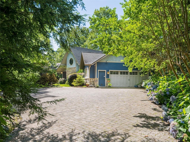 935 Whites Lake Blvd, Saluda, NC 28773 - view of front of home featuring an attached garage, stone siding, and decorative driveway