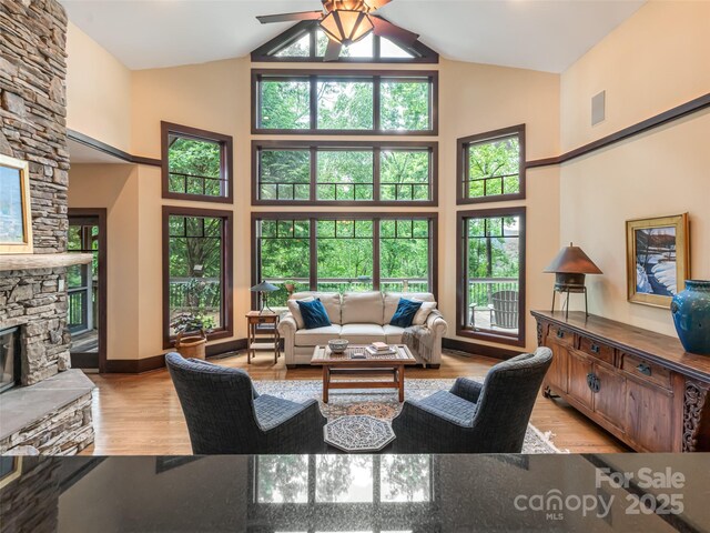 935 Whites Lake Blvd, Saluda, NC 28773 - living area featuring high vaulted ceiling, ceiling fan, healthy amount of natural light, a fireplace, and light wood-type flooring