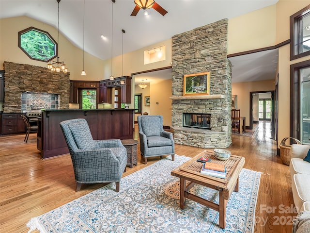 935 Whites Lake Blvd, Saluda, NC 28773 - living area with a stone fireplace, high vaulted ceiling, ceiling fan, and light wood-style flooring