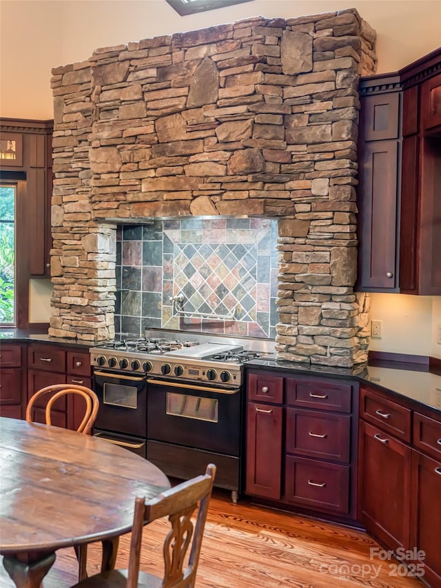 935 Whites Lake Blvd, Saluda, NC 28773 - kitchen featuring range with two ovens, dark brown cabinets, dark countertops, light wood-style floors, and tasteful backsplash