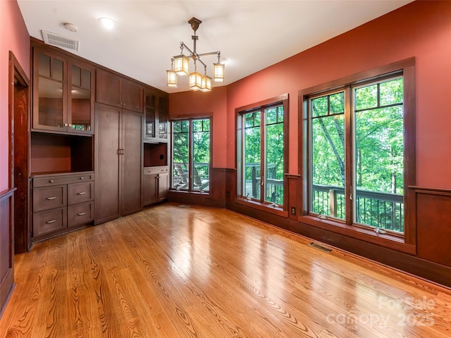 935 Whites Lake Blvd, Saluda, NC 28773 - empty room featuring a wainscoted wall, light wood-style floors, and a chandelier