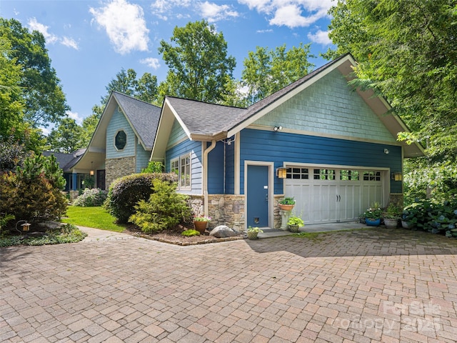 935 Whites Lake Blvd, Saluda, NC 28773 - craftsman-style home with stone siding, decorative driveway, an attached garage, and a shingled roof