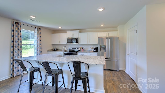 12 Wildbrook Dr, Waynesville, NC 28785 - kitchen featuring appliances with stainless steel finishes, a center island with sink, white cabinetry, a kitchen breakfast bar, and dark wood-style flooring