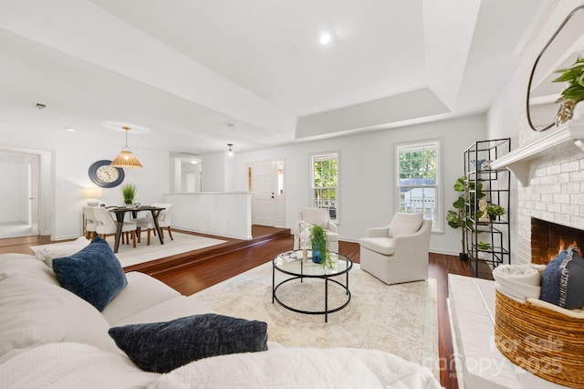 8806 Golf Ridge Dr, Charlotte, NC 28277 - living area featuring wood finished floors, a brick fireplace, a raised ceiling, and recessed lighting
