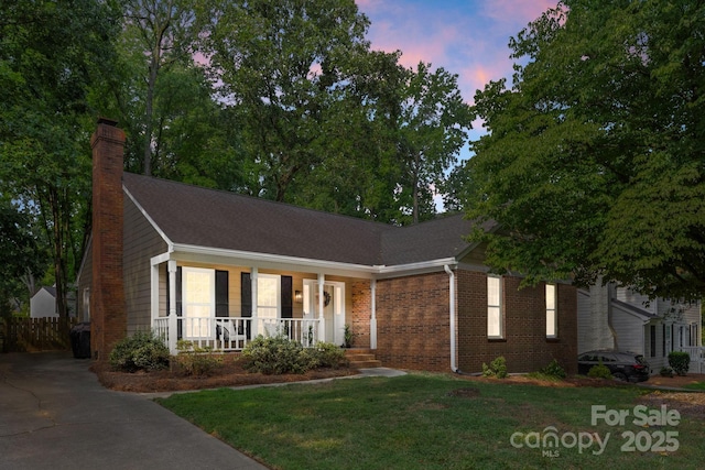 8806 Golf Ridge Dr, Charlotte, NC 28277 - ranch-style house featuring a porch, a chimney, a lawn, brick siding, and driveway