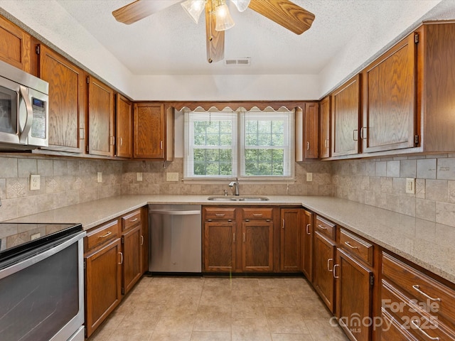 4601 Bournewood Ln, Charlotte, NC 28226 - kitchen with stainless steel appliances, ceiling fan, brown cabinetry, light countertops, and tasteful backsplash