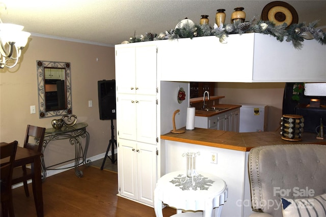 225 Emmett St, Rock Hill, SC 29730 - kitchen with dark wood finished floors, ornamental molding, white cabinetry, tile countertops, and a chandelier