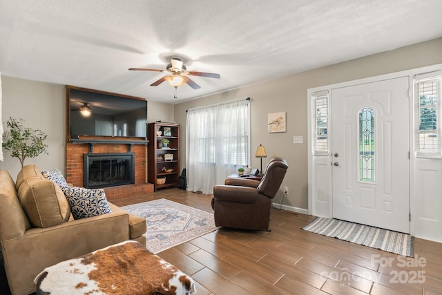 100 Pinecrest Ct, Taylorsville, NC 28681 - living room featuring a ceiling fan, a brick fireplace, wood finished floors, and a textured ceiling