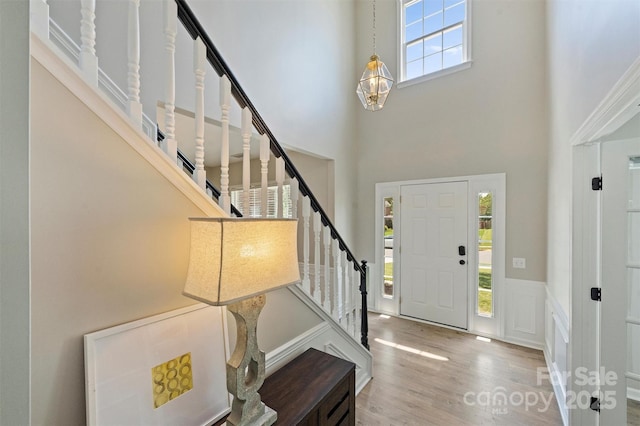 7930 Lancken Dr, Charlotte, NC 28277 - entryway featuring stairs, a high ceiling, wood finished floors, a wainscoted wall, and a decorative wall